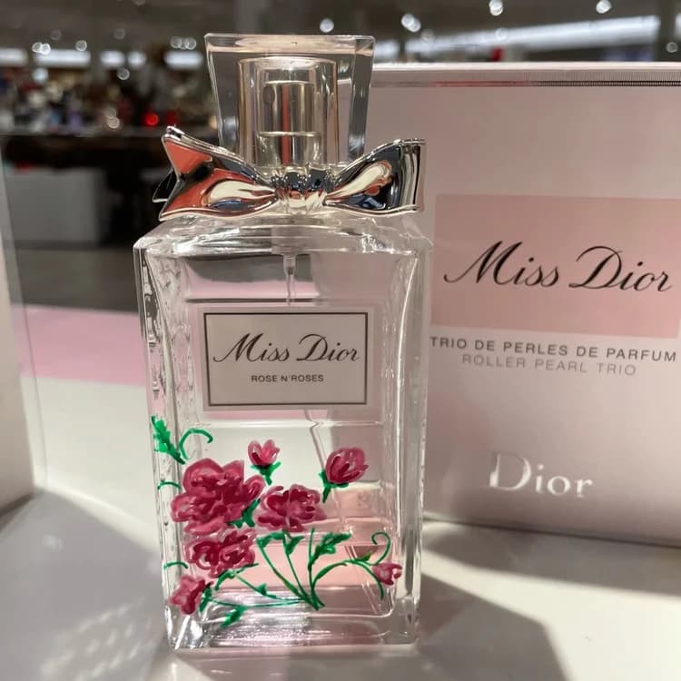 Detail of a hand-painted bottle on a mirror with gift packaging.