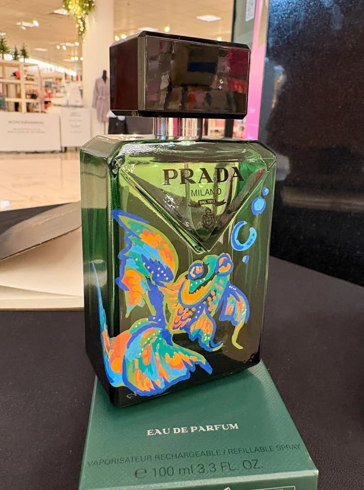 A green fragrance bottle painted with a vivid koi fish motif.