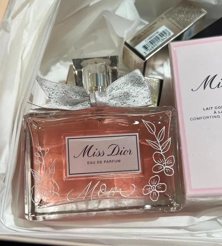 A fragrance bottle personalized with the word ‘Mom’ and delicate painted flowers.