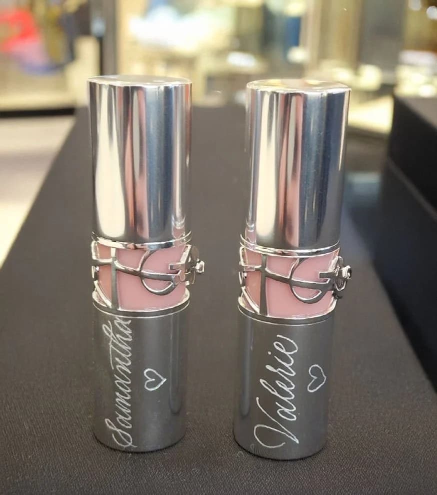 A personalized heel-shaped fragrance bottle with flowing gold calligraphy.